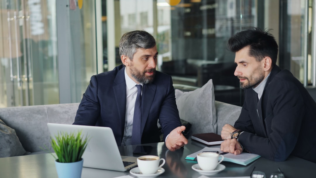 a-couple-of-men-sitting-at-a-table-in-front-of-a-laptop-gqve31dde3e